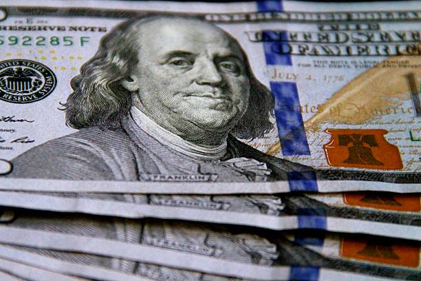 Blue One Hundred Dollar Bills New York City, United States - July 30, 2016: Blue American one hundred dollar bills fanned out horizontally including the artist rendering of Benjamin Franklin's bust in soft focus philadelphia federal reserve stock pictures, royalty-free photos & images