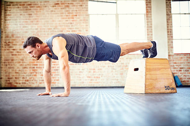 istock Fit young man doing push-ups on box in gym 584612874