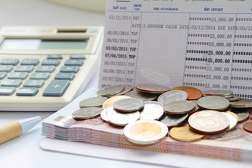 Monedas y dinero baht tailandés en la cuenta de ahorros photo