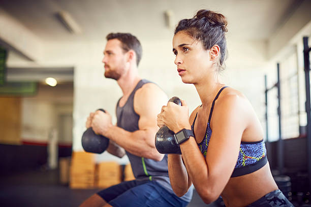 istock Determined fit woman with instructor exercising in gym 584613286