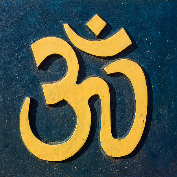 istock Yellow Om/Aum symbol on dark blue wall 584743572