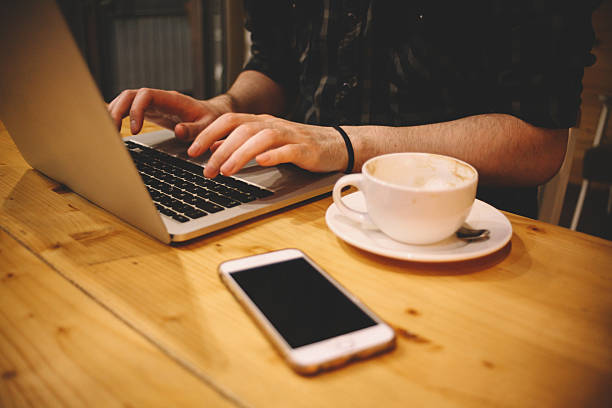 istock Young man sitting in a coffee shop using laptop 584744716