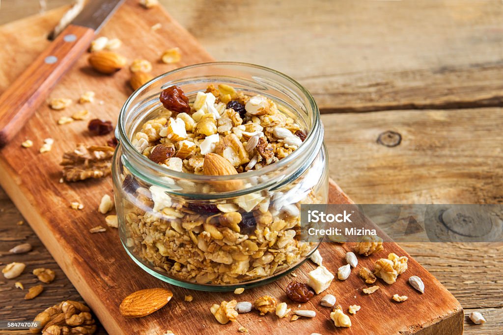 Homemade granola with nuts Homemade granola with nuts and seeds in glass jar for healthy breakfast Granola Stock Photo