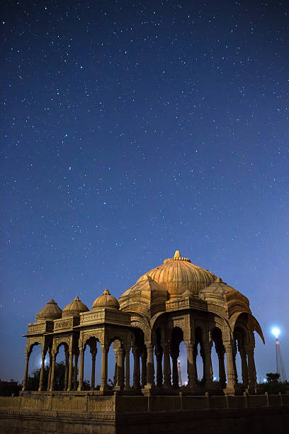 The royal cenotaphs of historic rulers in Jaisalmer The royal cenotaphs of historic rulers, also known as Jaisalmer Chhatris, at Bada Bagh in Jaisalmer, Rajasthan, India. Night shot of ruins with stars jainism photos stock pictures, royalty-free photos & images