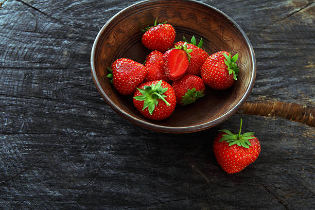 istock Red fresh strawberries on black rustic wood background 584749378