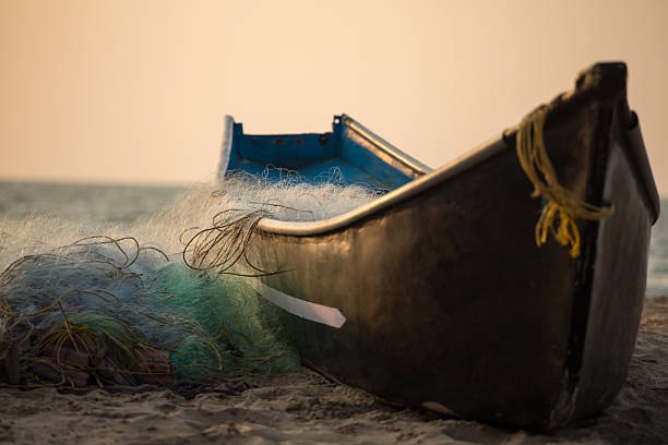 barca da pesca con reti da pesca sulla spiaggia di gokarna - fish sand beach horizontal foto e immagini stock