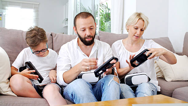 istock Family at home playing with virtual reality headsets. VR. 584752040