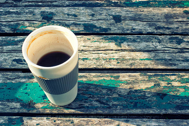istock Coffee on old wooden table in park on early morning 584755702