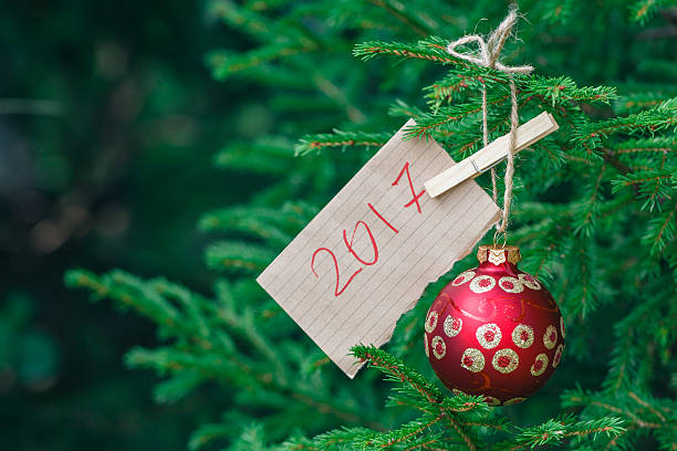 istock Great red Christmas ball hanging on a branch green pine 584755880