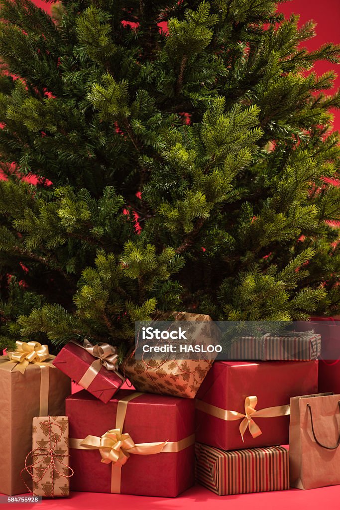 Christmas tree with gifts on red background Backgrounds Stock Photo