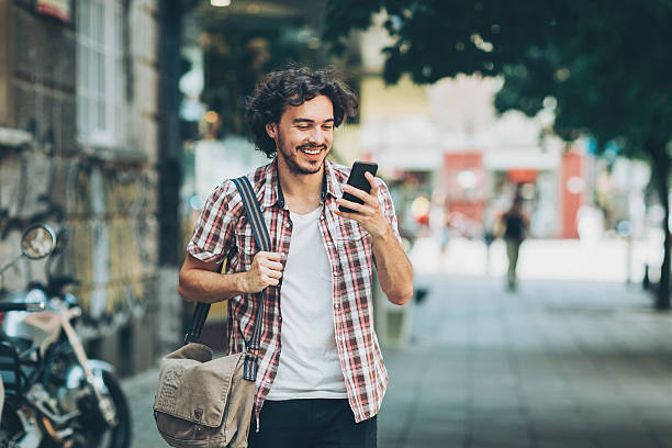 istock Young man texting on the street 584757772