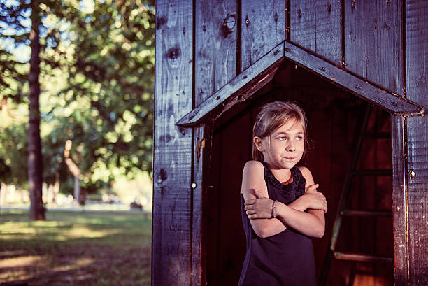 Little girl standing in a shade and feeling cold