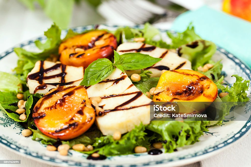 Salad with grilled halloumi cheese and peaches Fresh green salad with grilled halloumi cheese and peaches Halloumi Stock Photo