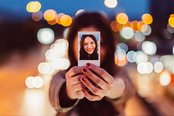 istock Young woman showing instant selfie 584763108