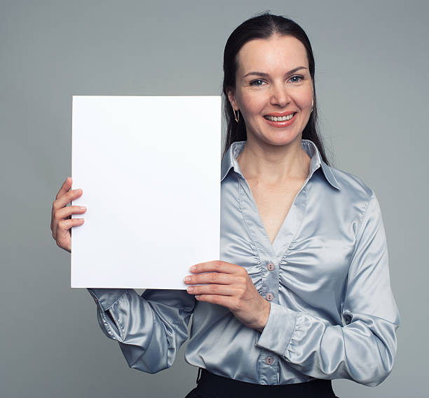 istock Smiling woman holding blank card 584766592