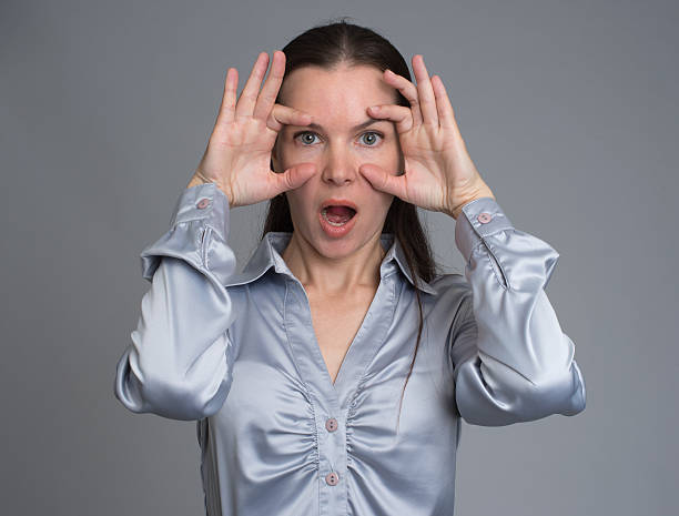 istock surprised young brunette woman. Grey background 584766840