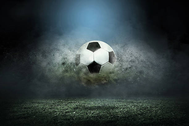 Moving soccer ball around splash drops on the stadium field.