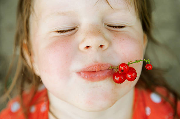 happy child with red currants - one baby girl only fotos imagens e fotografias de stock