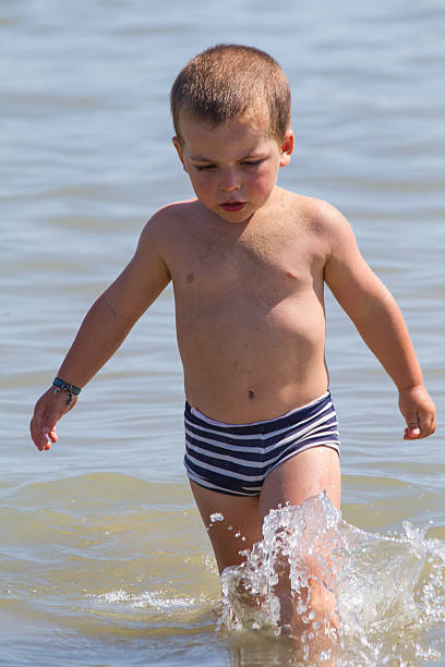Happy child runs into sea to swim, vacation in Italy Cesenatico