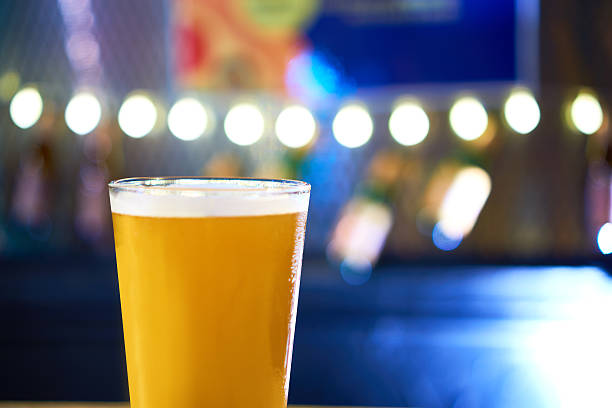 istock Glass of light beer on a dark pub table 584772212