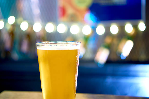 istock Glass of light beer on a dark pub table 584772462