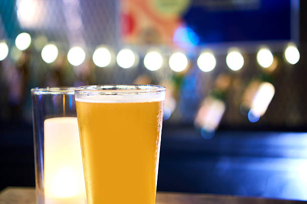 istock Glass of light beer on a dark pub table 584772624