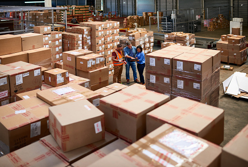 Shot of people at work in a large warehouse full of boxes