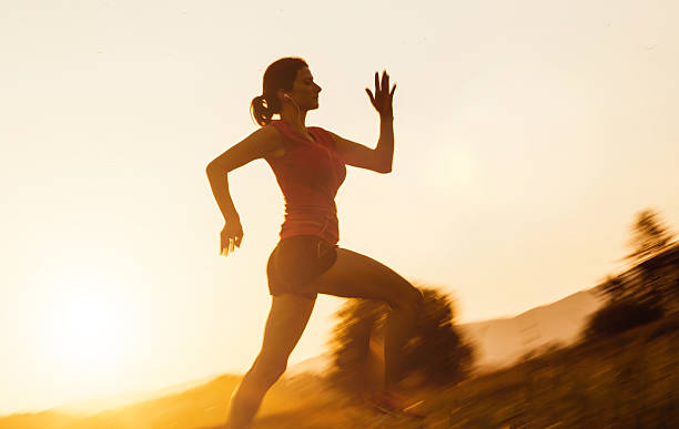 istock Young Woman Running Outdoors at Sunset 584773100