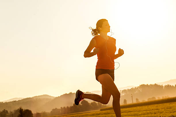 istock Young Woman Running Outdoors at Sunset 584773116