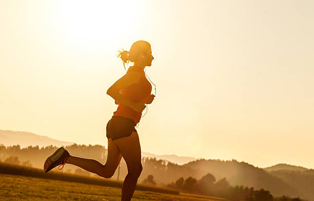 istock Young Woman Running Outdoors at Sunset 584773128