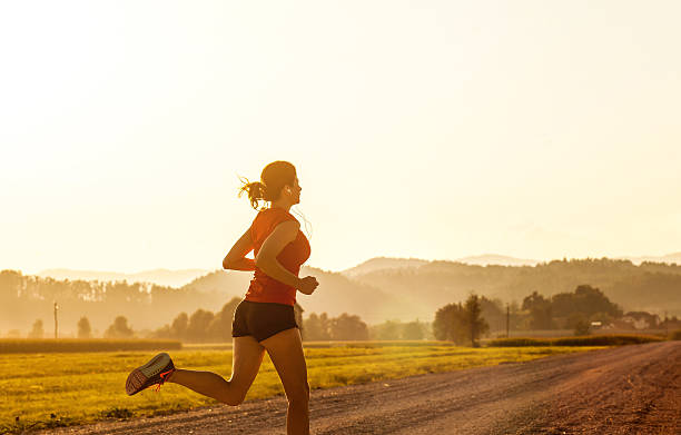 istock Young Woman Running Outdoors at Sunset 584773138