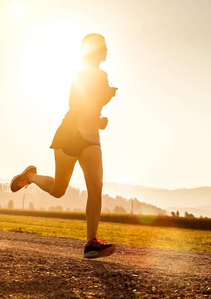 istock Young Woman Running Outdoors at Sunset 584773152