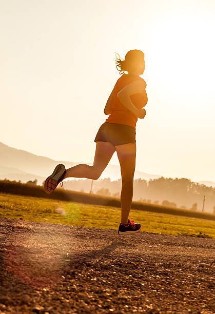 istock Young Woman Running Outdoors at Sunset 584773158