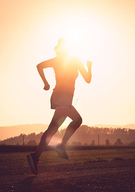 istock Young Woman Running Outdoors at Sunset 584773164