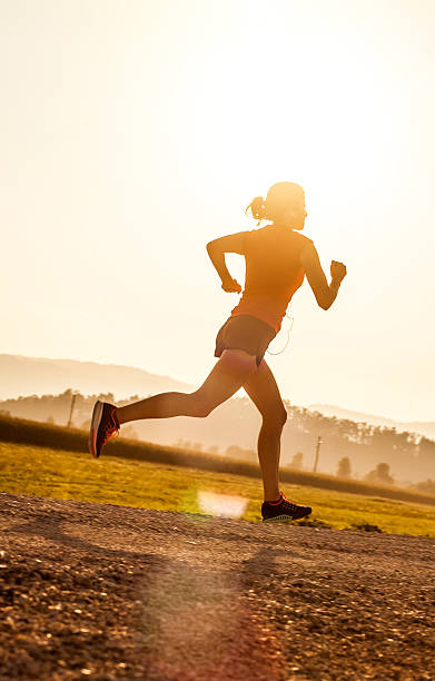 istock Young Woman Running Outdoors at Sunset 584773184