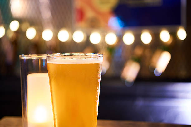 istock Glass of light beer on a dark pub table 584773220