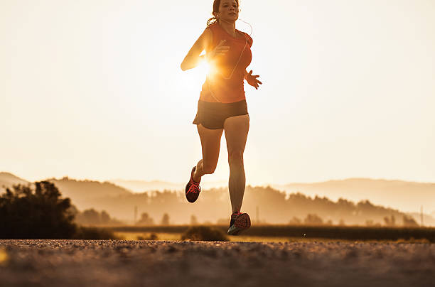 istock Young Woman Running Outdoors at Sunset 584773262