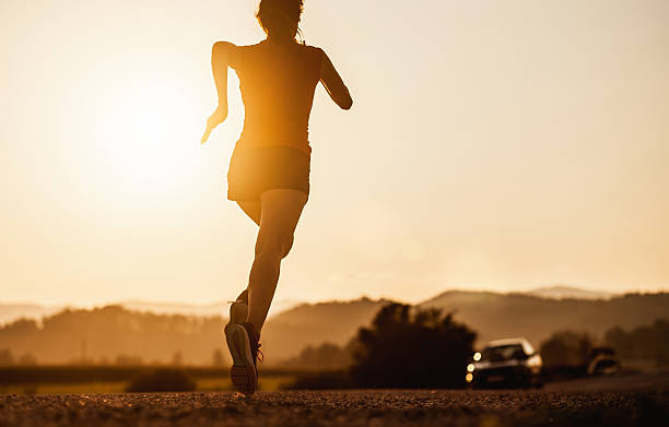 istock Young Woman Running Outdoors at Sunset 584773318