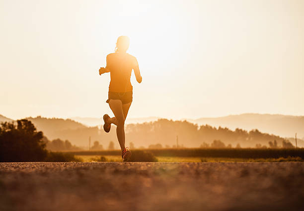 istock Young Woman Running Outdoors at Sunset 584773412