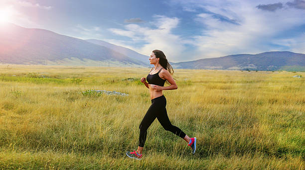 istock Young woman jogging in nature 584774428