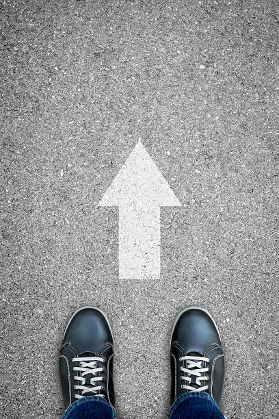 istock Black casual shoes and direction sign 584775828