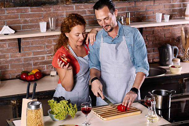 istock Woman looking how man cutting vegetable 584778078