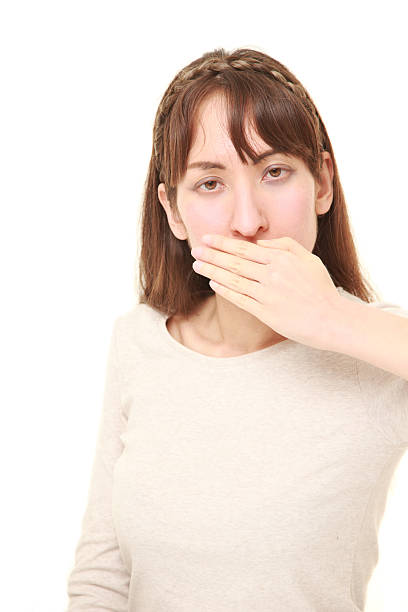 istock woman making the speak no evil gesture 584778946