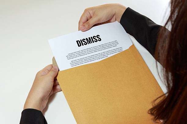 istock Businesswoman opening the dismiss document in letter envelope 584779152