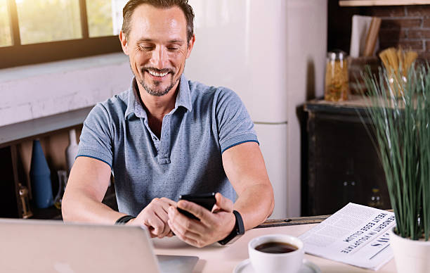 istock Smiling man looking at his phone 584780448