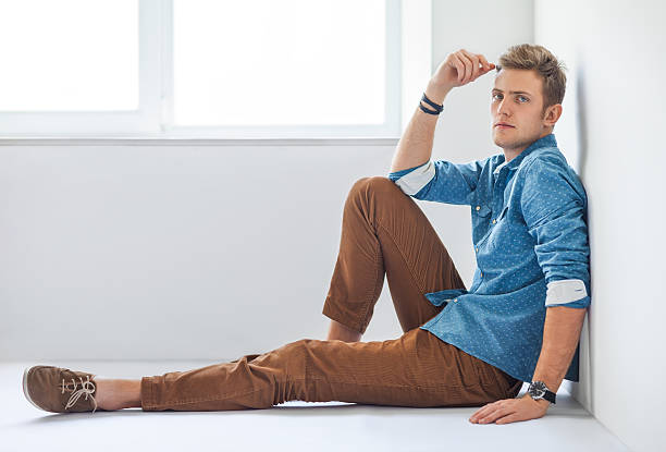 istock Handsome serious man sitting on the floor 584783518