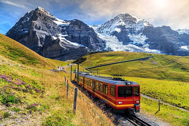 Famous electric red tourist train coming down from the Jungfraujoch station(top of Europe) in Kleine Scheidegg,Bernese Oberland,Switzerland,Europe