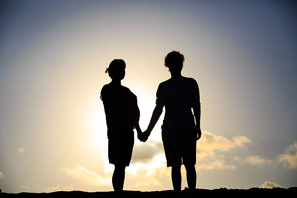 istock happy pregnant couple at sunset beach 584785950