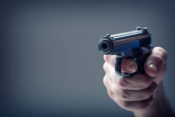 istock Weapon gun. Men's hand holding a gun. 9 mm pistol 584787082