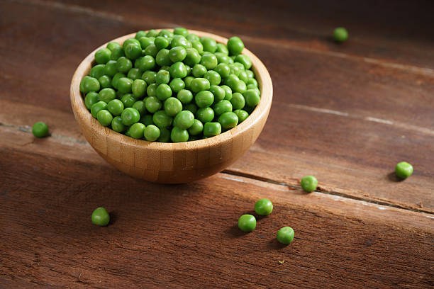 fresh green pea fresh green pea in bowl on wooden background Peas stock pictures, royalty-free photos & images